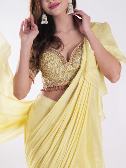Vibrant Yellow Saree With A Ruffled Design And Golden Embellished Blouse With A Plunging Neckline